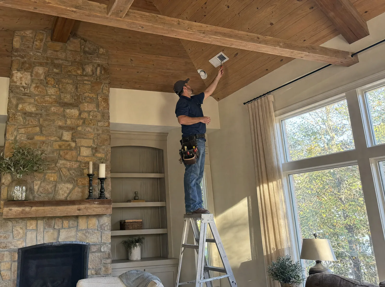 A technician checks the air at a ceiling register with a probe thermometer.