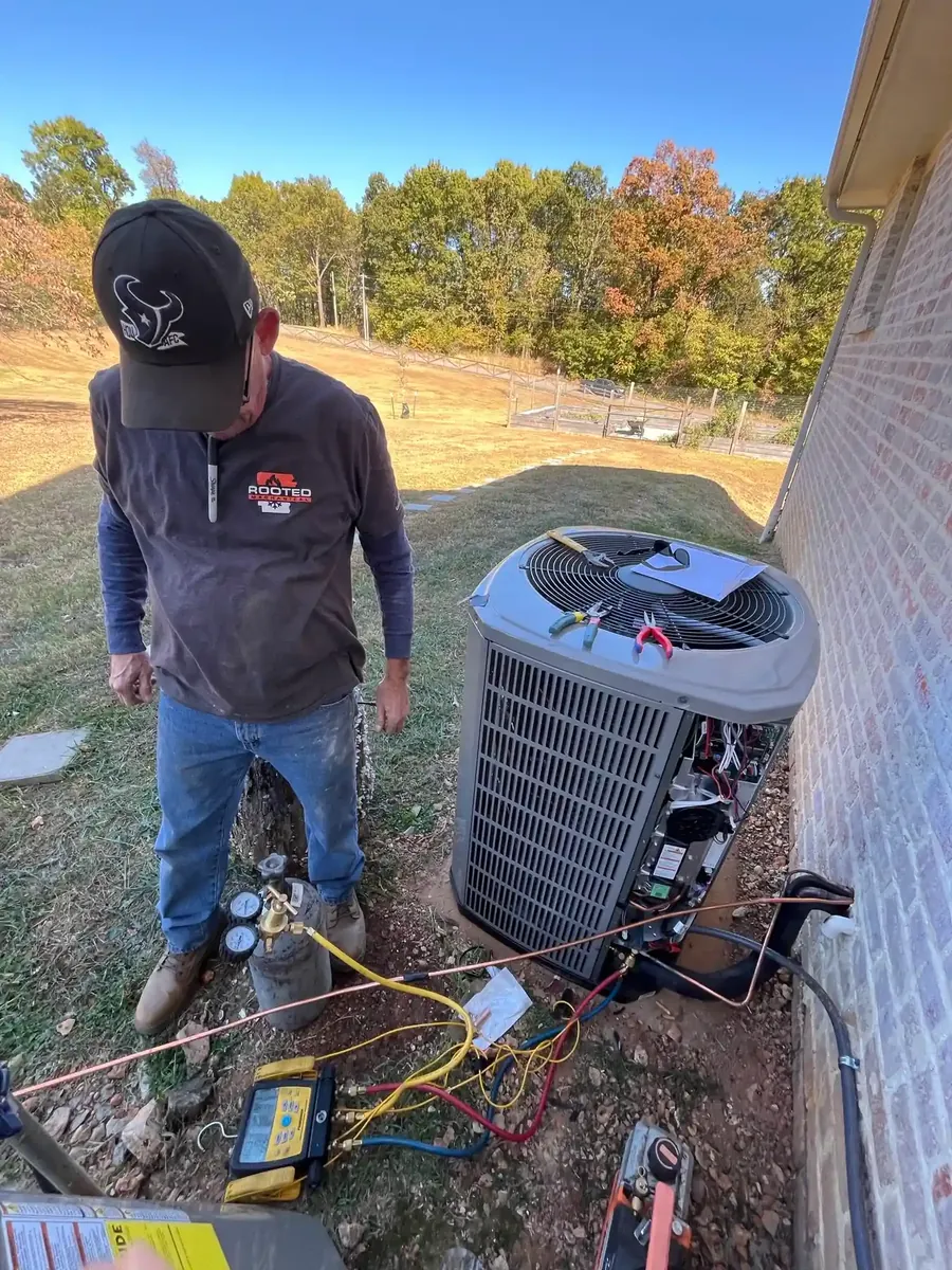 HVAC technician performing AC repair on a residential system in Northwest Arkansas