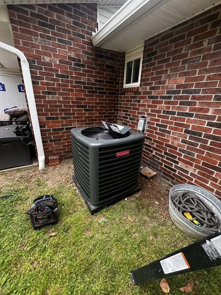 Vertical air handler in a utility closet with spiral duct above and a copper line set