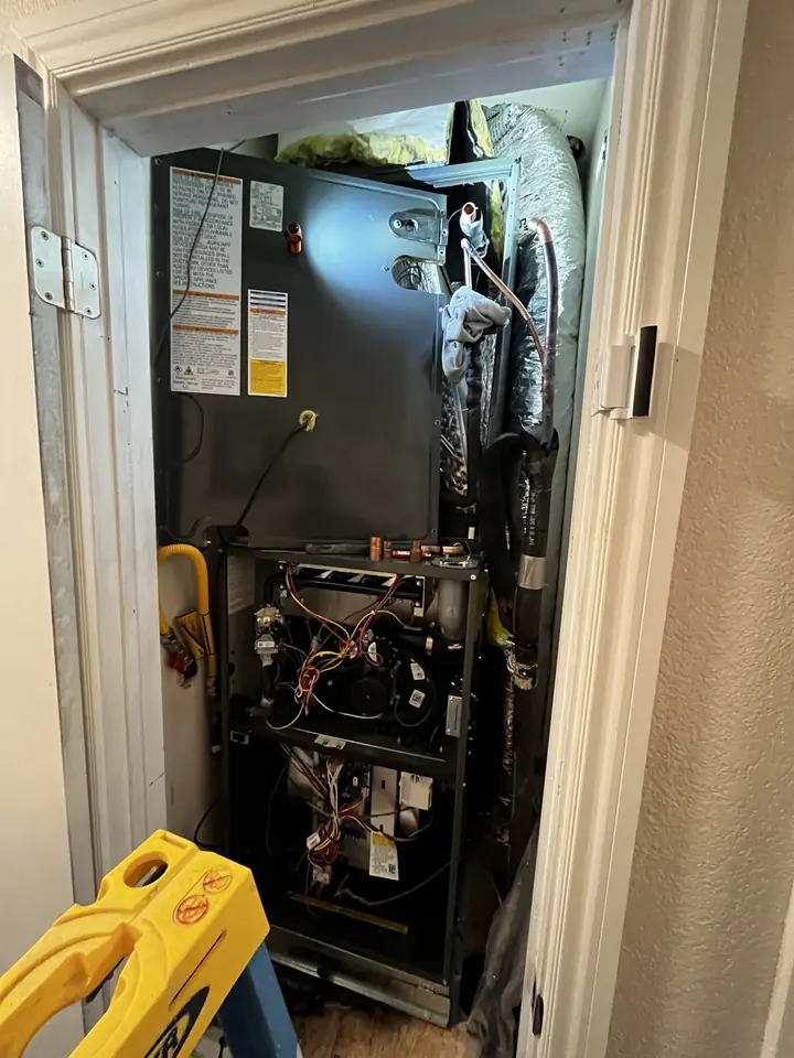 Insulated copper line set running through a brick wall to an outdoor HVAC unit