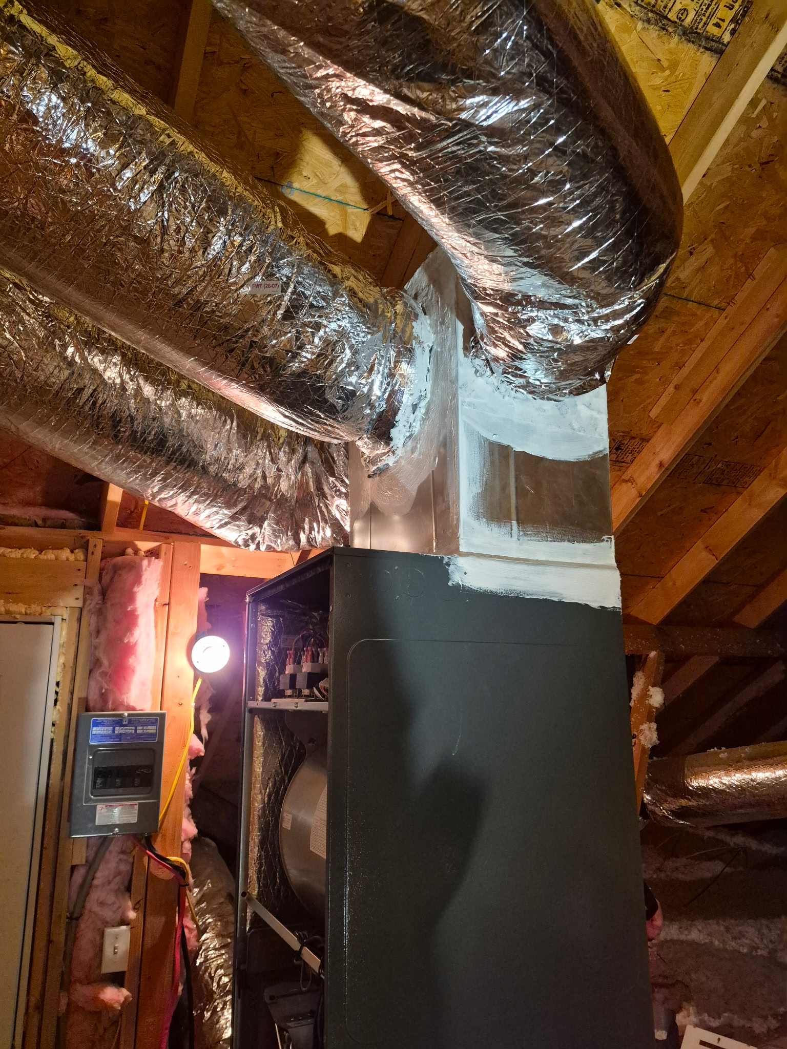 Technicians on a scissor lift installing rectangular ductwork above a commercial ceiling grid